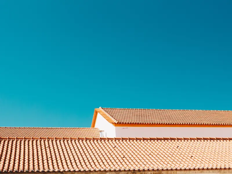 Orange terracotta tile roofline against a bright blue sky.