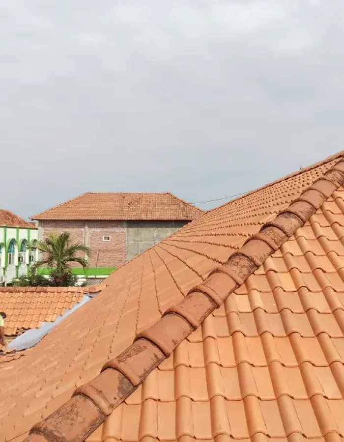 Terracotta tile roof with a worker in the background.