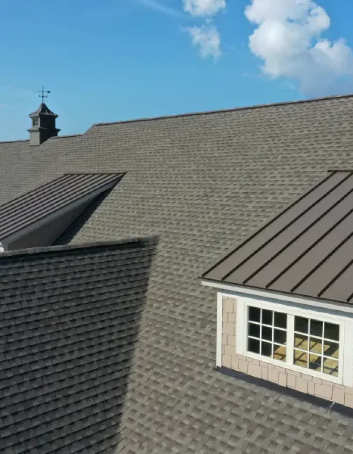 Shingle roof with metal-clad dormer windows.