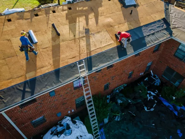Aerial view of workers installing a flat roof membrane.
